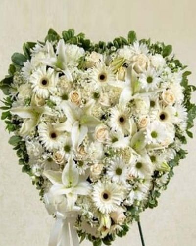 This solid heart standing spray makes a beautiful statement about your heartfelt compassion and sympathy. White flowers such as roses, lilies, Gerbera daisies, carnations and more form the solid heart which is tied to a wire easel with satin ribbon. Traditionally sent directly to the funeral home by family, friends or business associates.