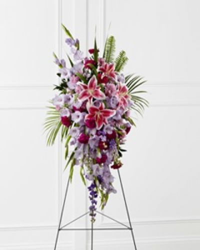 The FTD® Tender Touch™ Standing Spray creates an elegant display of beauty and color to enhance their final tribute. Lavender gladiolus, Stargazer lilies, fuchsia carnations, purple larkspur, lavender Peruvian lilies, lavender chrysanthemums, sword fern fronds, emerald palm fronds and other assorted greens are gorgeously arranged to create a sophisticated standing spray. Displayed on a wire easel, this arrangement will add to the sophistication of their service with each fragrant bloom.