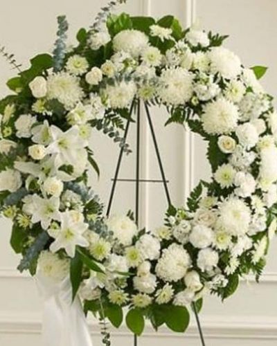 The Serene Sympathies Standing Wreath is a lovely reflection of the respect, love and compassion you want to express during this difficult time. Crafted by our expert florists, this standing wreath arrangement boasts fresh white flowers such as roses, football mums, and carnations accented by spiral eucalyptus, salal and more. Appropriate for family, friends and business associates to send directly to the funeral home.