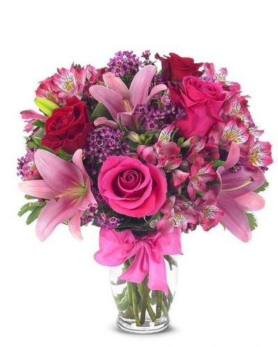 This sweetly flirtatious combination of Asiatic lilies, waxflower, alstroemeria and roses makes a thoughtful gift they'll not soon forget. A pretty pink ribbon and clear fluted glass vase add to the romantic look.