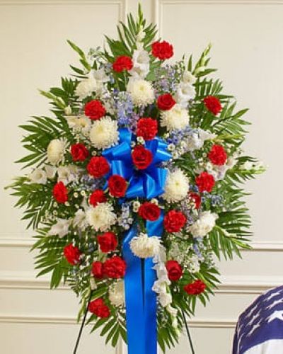 Honor a beloved veteran for their dedicated service with this heartfelt patriotic arrangement. Meticulously crafted by our expert florists using the freshest red, white and blue blooms, it perfectly conveys all the love, pride and sympathy you feel in your heart. This standing spray arrangement features fresh red, white and blue flowers such as roses, football mums, gladiolas, delphiniums, carnations and more. Appropriate for family, friends and business associates to send directly to the funeral home.