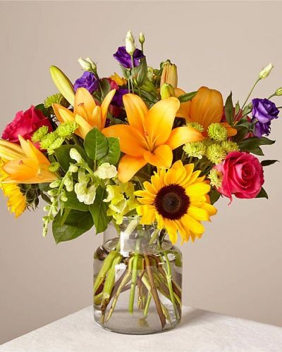 Make this day their best day. Our local florist handcraft a colorful array of flowers in a clear glass vase to create a celebration in bloom. Perfect to give for a special reason or to simply share a smile.