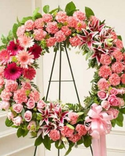 This pink standing wreath perfectly expresses your love and concern at this difficult time. Softly colored flowers such as roses, stargazer lilies, carnations and more are accented by salal and seeded eucalyptus. Traditionally sent directly to the funeral home by family, friends and business associates.