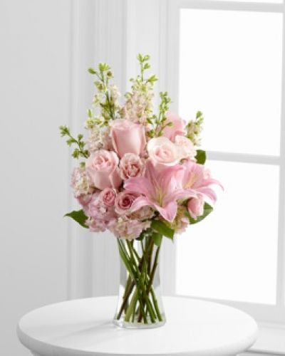 The FTD® Wishes & Blessings™ Bouquet is a stunning way to offer your condolences for their loss and commemorate the life of the deceased. Soft pink roses, spray roses, Oriental lilies, hydrangea and larkspur are brought together in a clear glass vase to create an eye-catching display of soft serenity.
